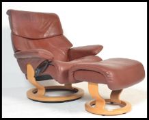 An Norwegian designer Ekornes leather revolving Stressless reclining chair with circular wooden base