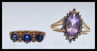 A hallmarked 9ct gold ring set with three purple stones with four white accent stones (hallmarked