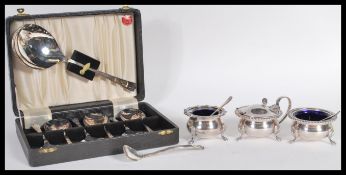 A pair of 20th Century silver white metal cruets, both having blue glass inserts and raised on