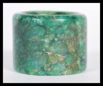 A 19th Century Chinese large mottled dark green jade archers thumb ring. 2.5cm high 3.5cm diameter.