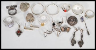 A collection of silver rings, earrings and brooches, the rings include a prong set ring with five