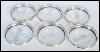 A set of six sterling silver coasters having cut glass bases. Stamped sterling.