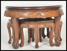 A 20th Century Carved Chinese hardwood coffee table / nest of tables, intricately carved to the