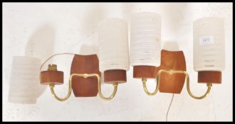 A pair of vintage retro wall sconces having teak wall brackets with brass arms with striped