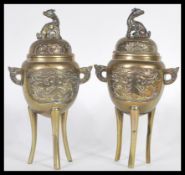 A pair of Chinese brass incense burners, each surmounted with the dog of Fo, and having panelled