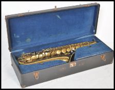 A 20th Century Elkhart saxophone with a gold lacquer finish having mother of pearl keys, set