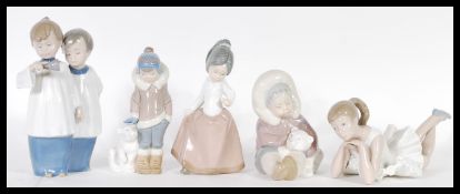 A collection of Lladro and Nao porcelain ceramic figurines to include Choirboys ringing a bell 01072