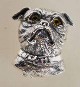 A sterling silver brooch / pendant in the form of a dog having yellow glass eyes. Weighs 13 grams.