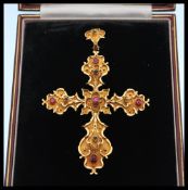 A 19th Century Victorian gold ruby and emerald gothic style crucifix having scrolled borders and