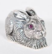 A sterling silver figurine in the form of a rabbit or hare having faceted red stone eyes. Weighs