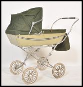 A vintage retro 20th Century Silver Cross childrens dolls pram, the hooded pram raised on a chrome