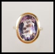 A hallmarked 9ct gold large purple stone ring having a large faceted purple stone in solid mount.