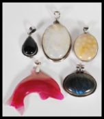 A selection of silver and precious stone pendants to include a labradorite pendant, a large white