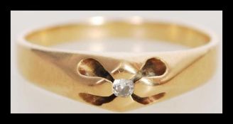 A stamped 18ct gold ring set with a brilliant cut white stone in a designer setting. Total weight