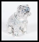 A sterling silver figurine in the form of a dog modelled in a seated position. Weighs 19 grams.