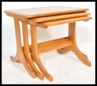 A 20th century Ercol style beech and elm graduating nest of tables. Raised on splayed legs, each