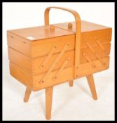 A vintage 20th century retro metamorphic sewing box having metamorphic movements. The fold out