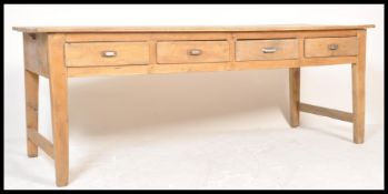 A large 19th century pine farmhouse refectory dining table being raised on squared legs having a