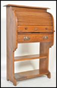 An early 20th Century Arts & Crafts oak students tambour fronted bureau, with shelf and a fall front