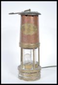 A vintage early 20th Century brass miners lamp having applied brass plaque being later converted