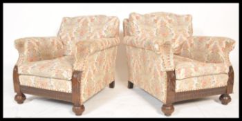 A pair of 1920's Chesterfield armchairs being raised on bun feet with castors having barrel arms and