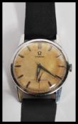 A vintage 20th Century Omega watch having a champagne dial with silver baton numerals and faceted