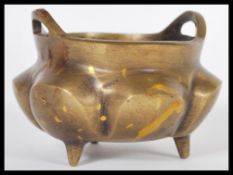 A 19th Century Chinese bronze censer ding prayer bowl raised on three conical feet with shaped