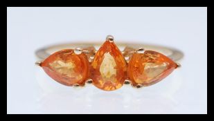 A 9ct gold hallmarked ring prong set with three pear shaped orange stones. Hallmarked Birmingham