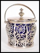 An early 20th Century hallmarked silver large jam or condiment pot having original blue glass liner.