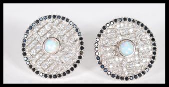A pair of sterling silver CZ and opal panelled stud earrings of circular form having central opal