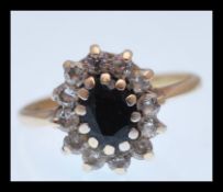 A hallmarked 9ct gold ring set with an oval cut blue stone with a halo of white stones. Size O.