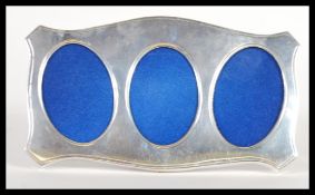 A contemporary Italian silver triptych portrait picture frame having three oval framed with wooden