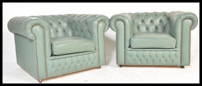 A pair of 20th Century mint green leather chesterfield armchairs with a barrel rolled arms and