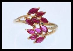 A hallmarked 9ct gold ring in the form of tree branches set with marquise cut red stones. Hallmarked