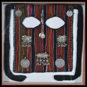 A framed and mounted fabric face veil of probable North African origin, the veil constructed from