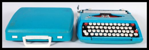 A vintage retro 20th Century portable typewriter set within a vibrant blue case with carry handle.