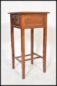 An Edwardian mahogany pedestal sewing box being raised on squared legs with hinged top enclosing