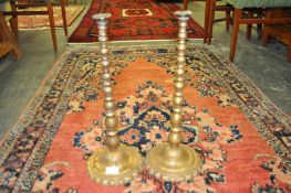 A pair of large 19th Century Victorian brass push candle sticks, raised on a scalloped base having a