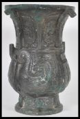 A 20th Century Chinese bronze vase raised on circular pedestal base with bulbous body and flared rim