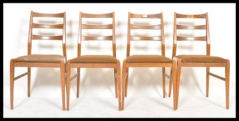 A set of four retro 20th Century teak wood rail back dining chairs, upholstered seat pads raised