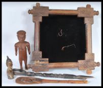 A collection of wooden carvings to include an African Totem tribal staff, a carved paddla from