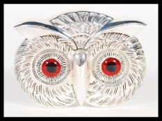 A silver plated vesta case or match holder in the form of an owls head having red glass eyes and