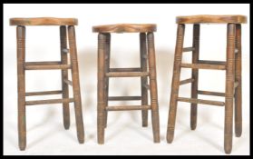 A good run of early 20th century beech and elm wood stools being raised on ring turned legs with