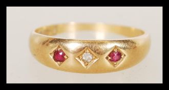 An 18ct gold ruby and diamond ring inset with 2 round cut ruby stones being within star gypsy