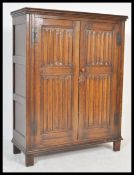 A good late 19th century oak linen fold cupboard being raised on stile legs with twin panel linen