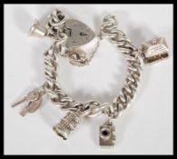 A sterling silver charm bracelet, with each link being stamped, consisting of six various charms, to