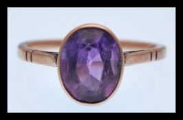 A 9ct gold ring set with a large oval faceted purple stone. Size 2.7g. Weight 2.6g.