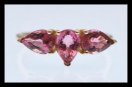 A hallmarked 9ct gold ring sprong set with three pear shaped pink stones. Hallmarked Birmingham.