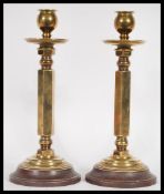 A pair of early 20th Century fine quality heavy brass candlesticks raised on stepped circular