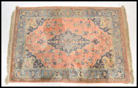 A 20th Century Persian Islamic carpet rug on a red ground having a blue border with floral geometric
